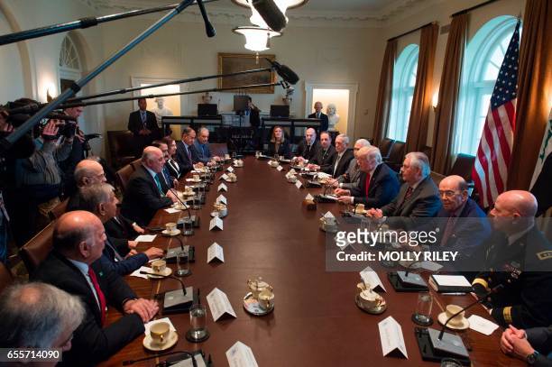 President Donald Trump listens while Iraqi Prime Minister Haider Al-Abadi speaks during their meeting in the Cabinet Room in the White House on March...