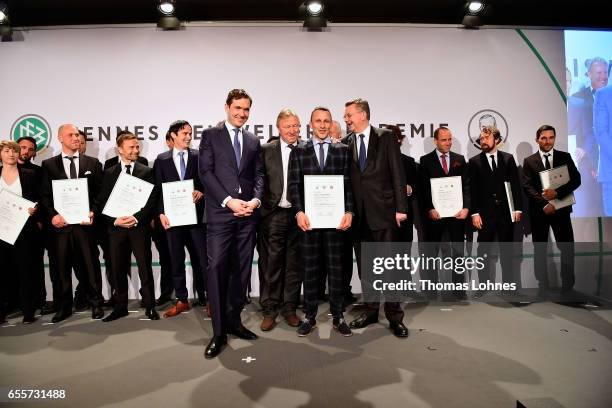 The new fototball coach Josef Steinberger stands with his certificate between DFB general secretary Friedrich Curtius, Horst Hrubesch and DFB...