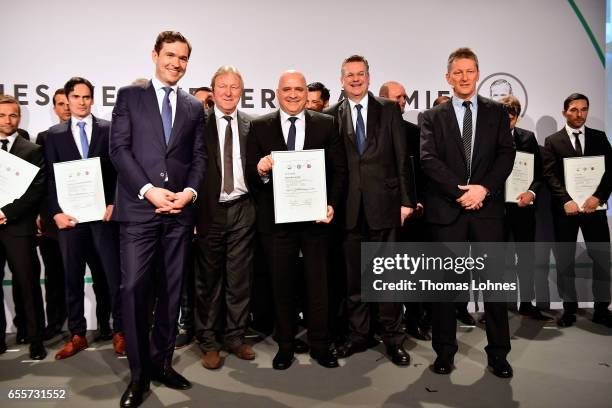 The new fototball coach Volcan Uluc stands with his certificate between DFB general secretary Friedrich Curtius, Horst Hrubesch, DFB president...