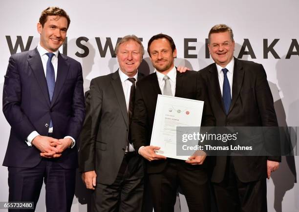 The new DFB foottball coach Heiko Gerber stands with his certificate between DFB general secretary Friedrich Curtius, Horst Hrubesch and DFB...