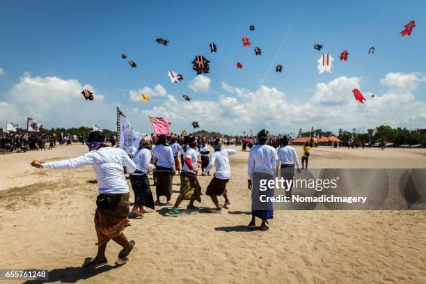 participants of kite flying competition flying kites on bali beach - indonesian kite stock pictures, royalty-free photos & images