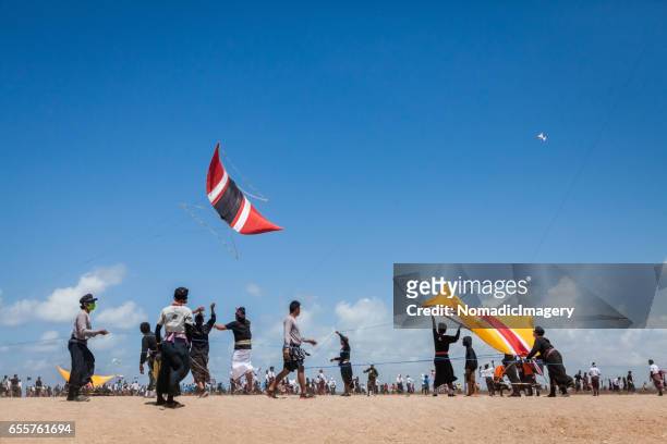 crowd of people on bali beach at kite flying competition - indonesian kite stock pictures, royalty-free photos & images