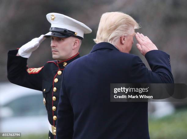 President Donald Trump salutes a U.S. Marine before boarding Marine One while departing from the White House, on March 20, 2017 in Washington, DC....