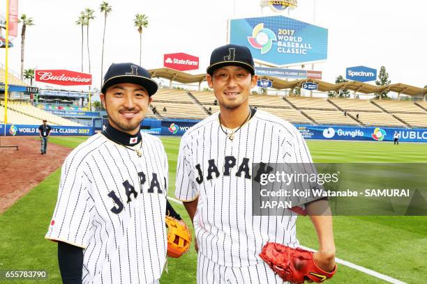 Sho Nakata and Ryosuke Kikuchi of Japan look on during a training session ahead of the World Baseball Classic Championship Round at Dodger Stadium on...