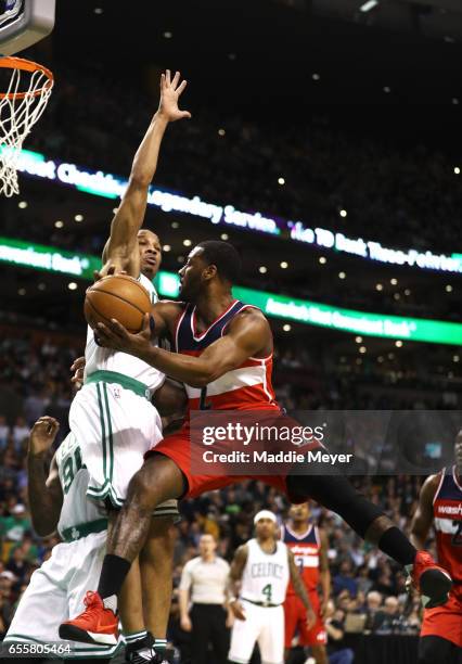 Avery Bradley of the Boston Celtics defends a shot by John Wall of the Washington Wizards during the second quarter at TD Garden on March 20, 2017 in...