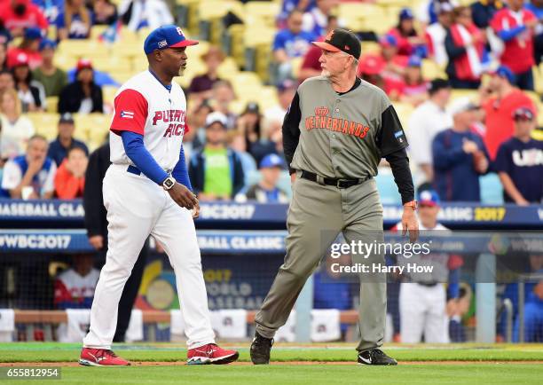 Carlos Delgado a coach of team Puerto Rico and Bert Blyleven a coach of team Netherlands walk out to throw a ceremonial pitch at the start of Game 1...