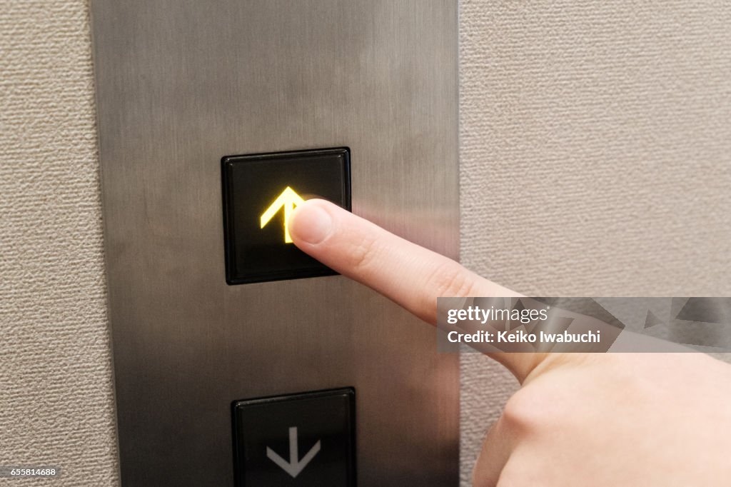 Pushing elevator button of upward arrow