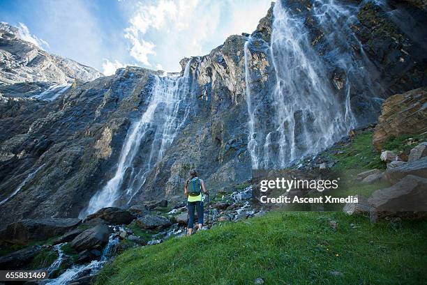hiker pauses below waterfall to admire view - cascade france stock pictures, royalty-free photos & images