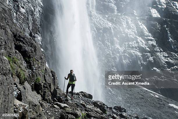 hiker pauses below waterfall to admire view - gavarnie stock-fotos und bilder