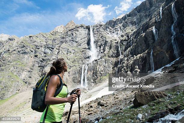 hiker pauses below waterfall to admire view - hautes pyrenees fotografías e imágenes de stock