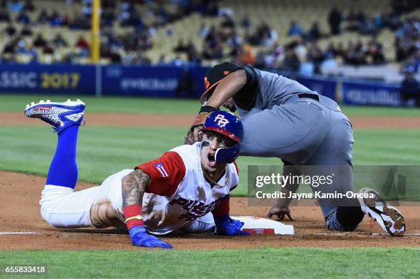Javier Baez of the Puerto Rico is safe as he beats the tag by Xander Bogaerts of the Netherlands in the during Game 1 of the Championship Round of...