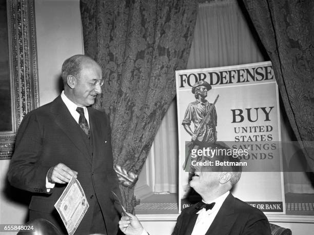 President Roosevelt buys the first of the government's New Defense Savings Bonds from Treasury Secretary Morgenthau. Speaking from the White House,...