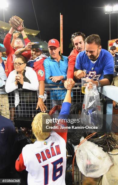 Angel Pagan of team Puerto Rico celebrates with fans after their 4-3 win over team Netherlands after an 11-inning Game 1 of the Championship Round of...