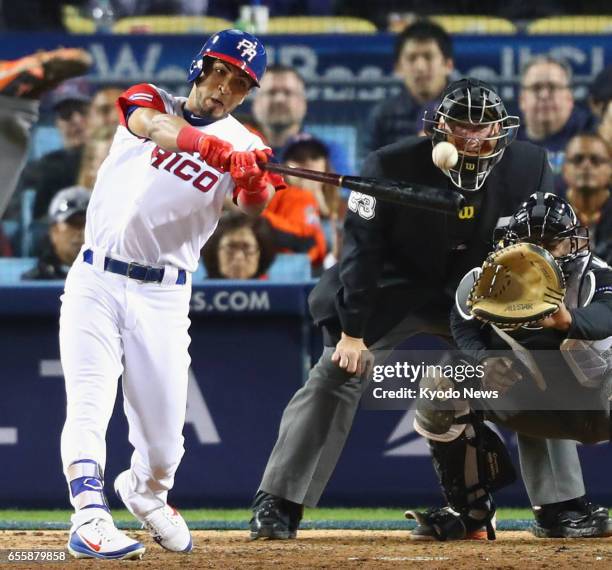 Eddie Rosario of Puerto Rico hits a sacrifice fly with the bases loaded, scoring the decisive run during the 11th inning of the team's 4-3 win...