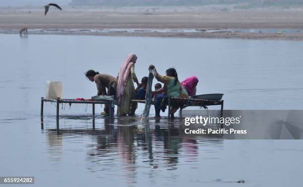 Women washed their clothes in the Ravi river bank in ahead of International World Water Day. International World Water Day is held annually on March...