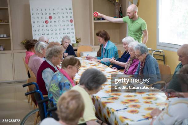 senioren spielen bingo in den ruhestand-gemeinschaft - bingo caller stock-fotos und bilder