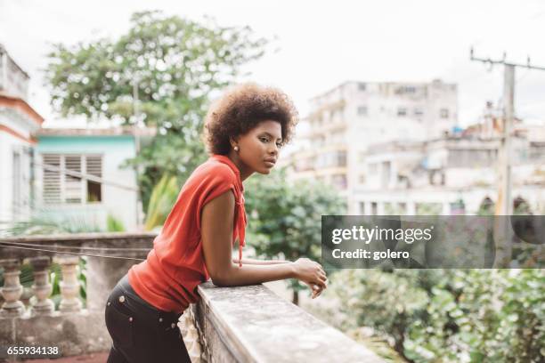 beautiful young cuban woman on balcony in havanna - leaning on elbows stock pictures, royalty-free photos & images