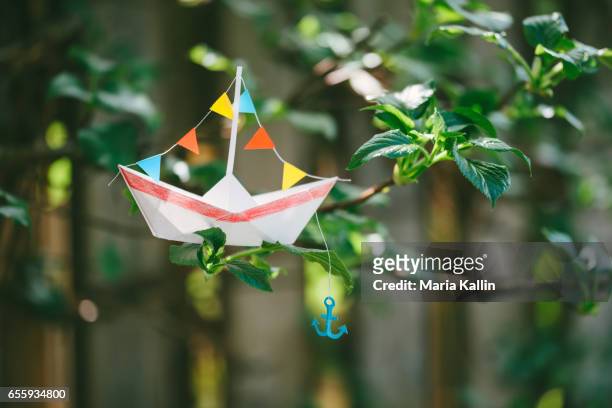 paper boat with anchor - paper boat stock-fotos und bilder