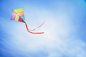 colorful kite flying with waving red bow