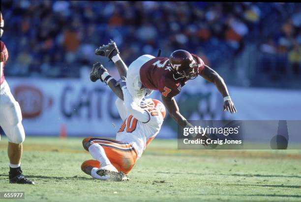 Quaterback Michael Vick the Virginia Tech Hokies is tackled by Charles Hafley of the Clemson Tigers during the Gator Bowl Game at the Gator Bowl in...