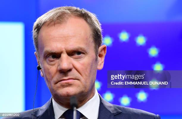 European Council President Donald Tusk reacts during a press statement announcing that an EU leaders' summit will take place to decide the political...