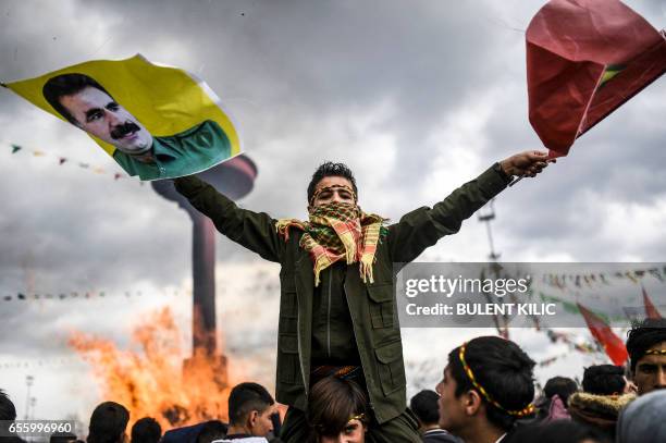 Kurdish boy waves flags with a picture of jailed Kurdish leader Abdullah Ocalan as Turkish Kurds gather for Newroz celebrations for the new year in...