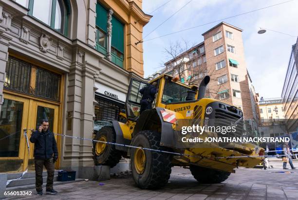 Police inspect the scene of a failed smash and grab attack on a Chanel boutique in Stockholm on March 21, 2017.