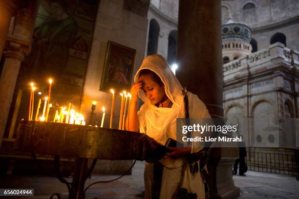 Woman prays next to The tomb of Jesus Christ with the rotunda is seen in the Church of the Holy Sepulchre on March 21, 2017 in Jerusalem, Israel. The...