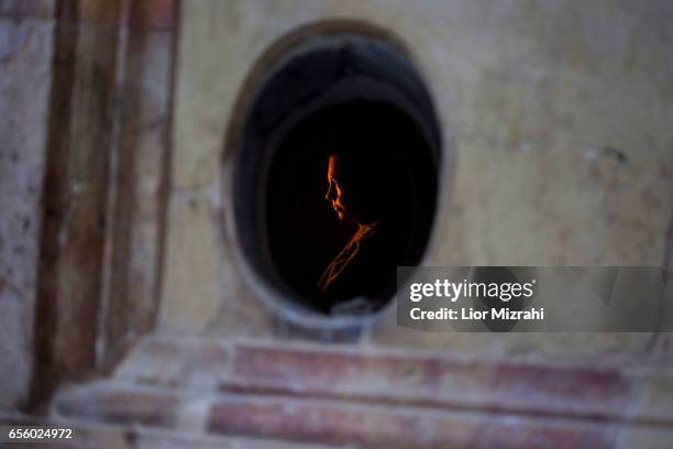 Woman prays inside The tomb of Jesus Christ in the Church of the Holy Sepulchre on March 21, 2017 in Jerusalem, Israel. The tomb of Jesus Christ in...