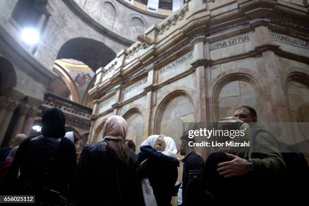 People visit The tomb of Jesus Christ with the rotunda is seen in the Church of the Holy Sepulchre on March 21, 2017 in Jerusalem, Israel. The tomb...