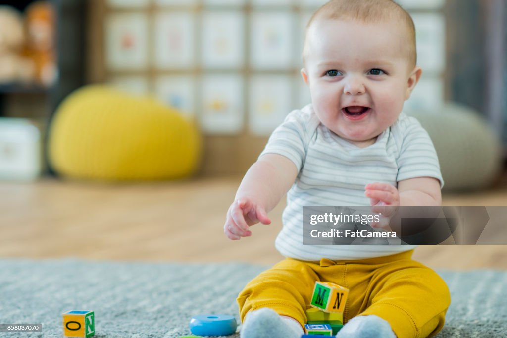 Baby spielt mit Häuserblocks