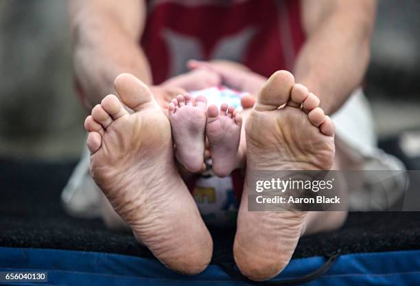 showing the bottom of the bare feet of a father and baby son sitting outside. - voetzool stockfoto's en -beelden