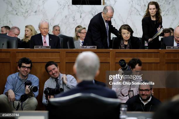 Senate Judiciary Committee Chairman Charles Grassley helps ranking member Sen. Dianne Feinstein take her seat after she arrived late for the second...