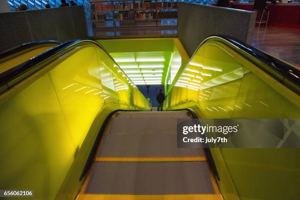 yellow neon escalator inside the seattle public library - seattle public library stock pictures, royalty-free photos & images