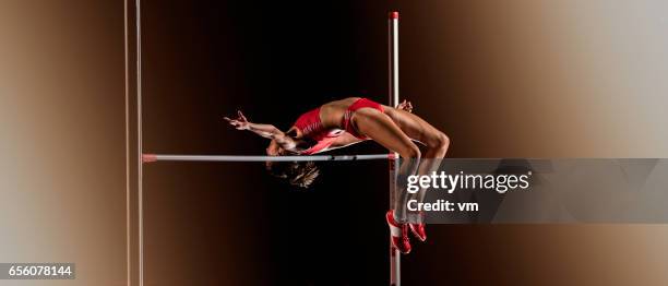 woman jumping over a horizontal bar during high jump - vaulting stock pictures, royalty-free photos & images