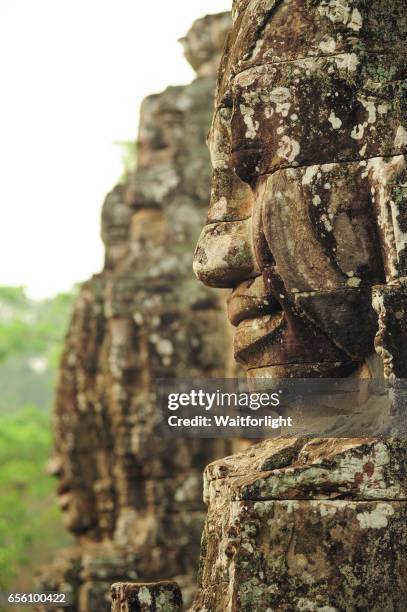 carving of a face at bayon temple - bayontempel stockfoto's en -beelden