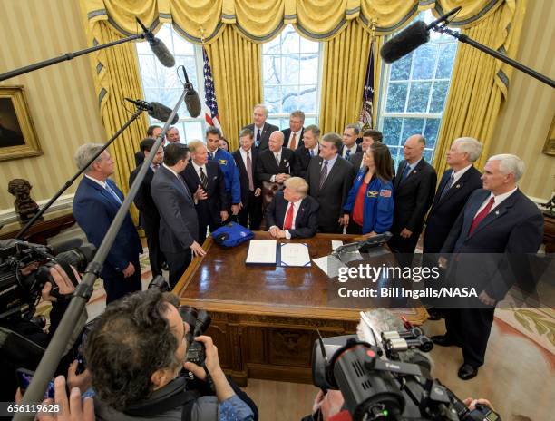 In this handout provided by the National Aeronautics and Space Administration , President Donald Trump, center, listens to Sen. Bill Nelson, D-Fla.,...