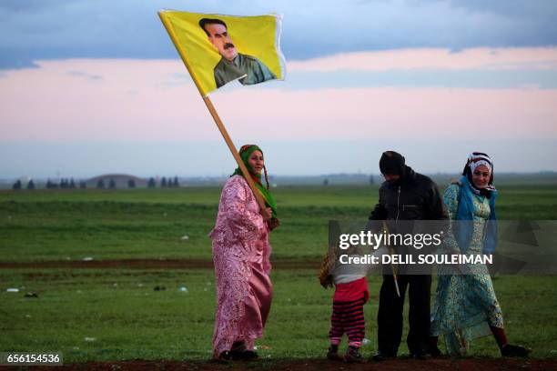Syrian Kurdish woman holds a portrait of jailed Kurdish rebel chief Abdullah Ocalan during the annual celebrations of Noruz, the Persian New Year, on...
