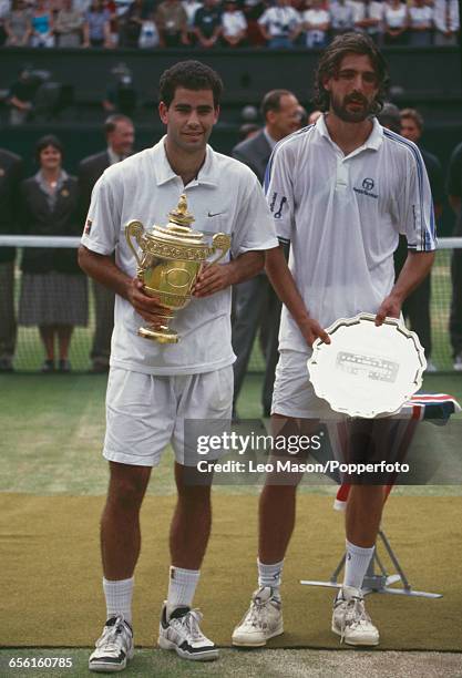 American tennis player Pete Sampras pictured left holding the Gentlemen's Singles Trophy with defeated Croatian tennis player Goran Ivanisevic on...