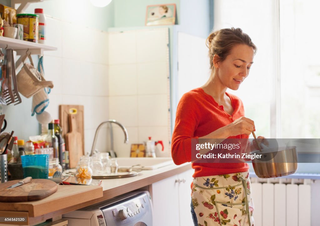 Woman in her kitchen making marmalade