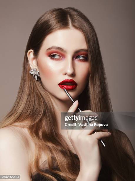 young woman applying red lipstick - lipstick applicator stock pictures, royalty-free photos & images
