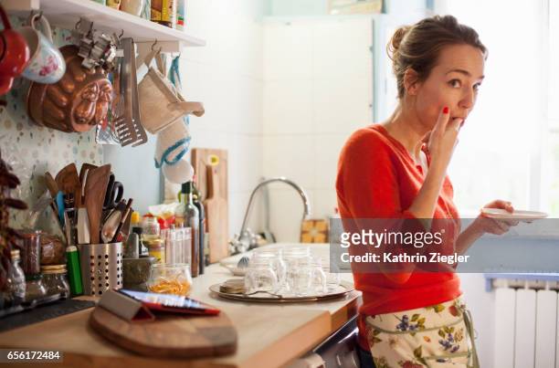 woman tasting freshly made marmalade from saucer - temptation stock-fotos und bilder
