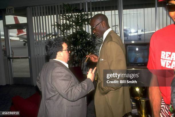 Chicago Bulls Michael Jordan talking with General Manager Jerry Krause in airport. NBA championship trophy on table behind Jordan. Los Angeles, CA...