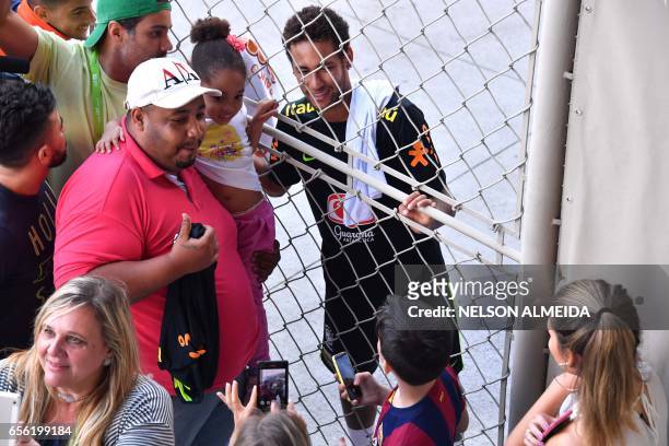 Brazil's national football team player Neymar poses for fans after a training session at the Corinthians team training centre in Sao Paulo, Brazil on...