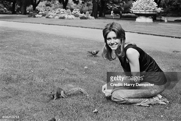 Singer and actress Olivia Newton-John in the park with a squirrel, UK, 10th August 1971.