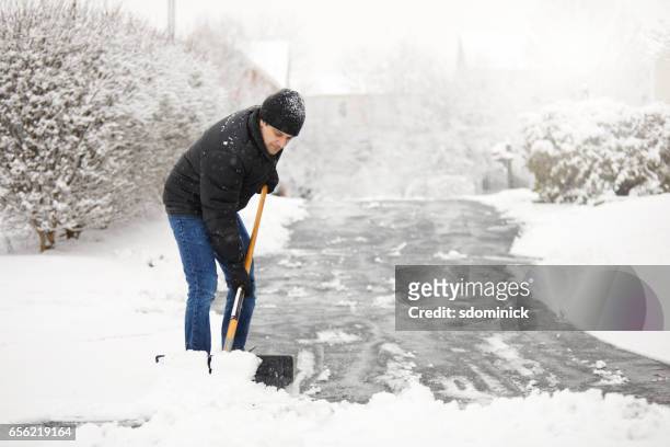 palear la nieve de la calzada - shovel fotografías e imágenes de stock