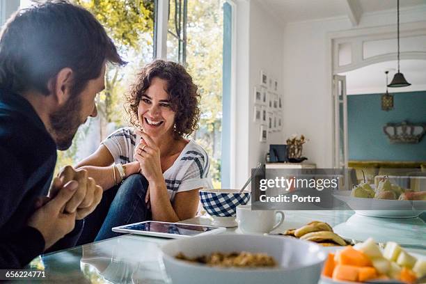 happy woman talking with spouse during breakfast - dish networks stock pictures, royalty-free photos & images