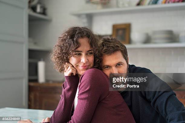 man is leaning on female partner at home - pareja de mediana edad fotografías e imágenes de stock
