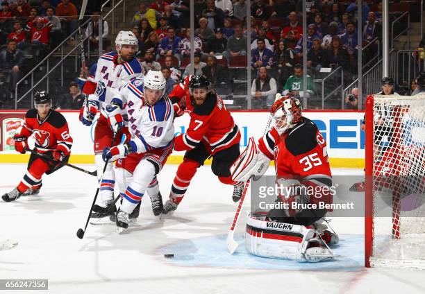 Jon Merrill and Cory Schneider of the New Jersey Devils defend against J.T. Miller of the New York Rangers during the first period at the Prudential...
