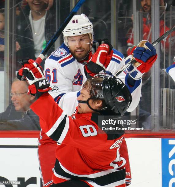Beau Bennett of the New Jersey Devils is hit Rick Nash of the New York Rangers during the first period at the Prudential Center on March 21, 2017 in...